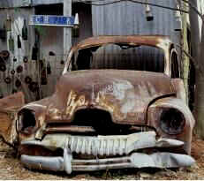 Old rusted car in old rusted tin shed